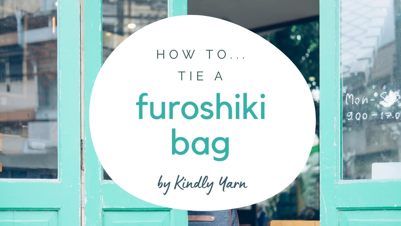 Load video: how to tie a scarf bag, or furoshiki bag, video tutorial. Shows 2 ways, a teardrop bag and a bag with bamboo hoop handles